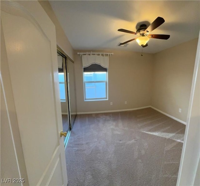 unfurnished bedroom with carpet, a closet, visible vents, a ceiling fan, and baseboards