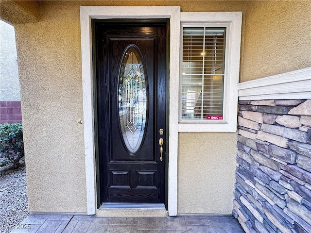 doorway to property featuring stucco siding