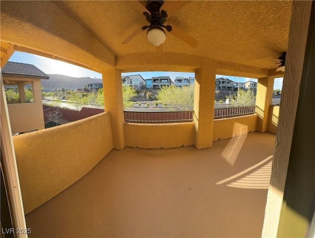 view of patio / terrace with a balcony, ceiling fan, and a mountain view