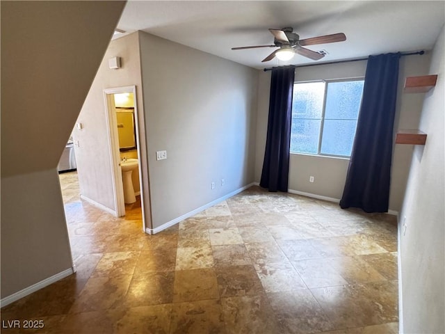 unfurnished room with ceiling fan and baseboards