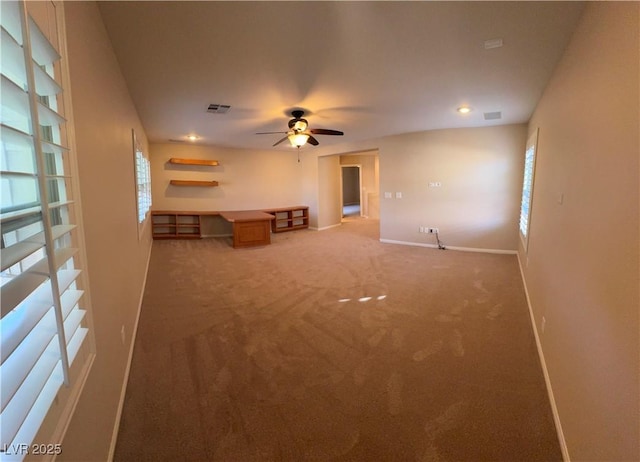 unfurnished living room featuring light carpet, visible vents, baseboards, and a ceiling fan