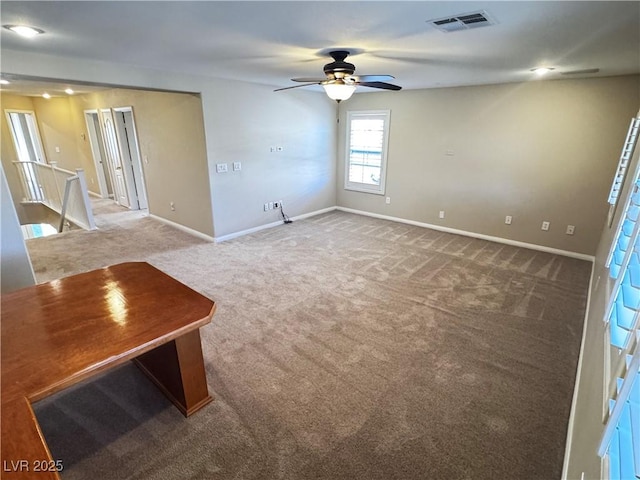 unfurnished living room with carpet, visible vents, and baseboards