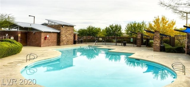 community pool with fence and a patio