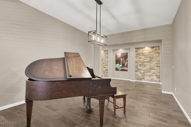 living area featuring baseboards, vaulted ceiling, and wood finish floors