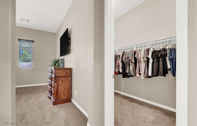 hallway featuring carpet, visible vents, and baseboards