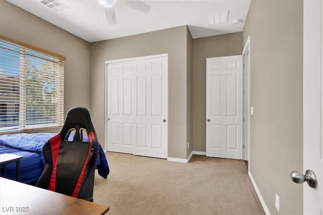 carpeted home office featuring baseboards, visible vents, and ceiling fan