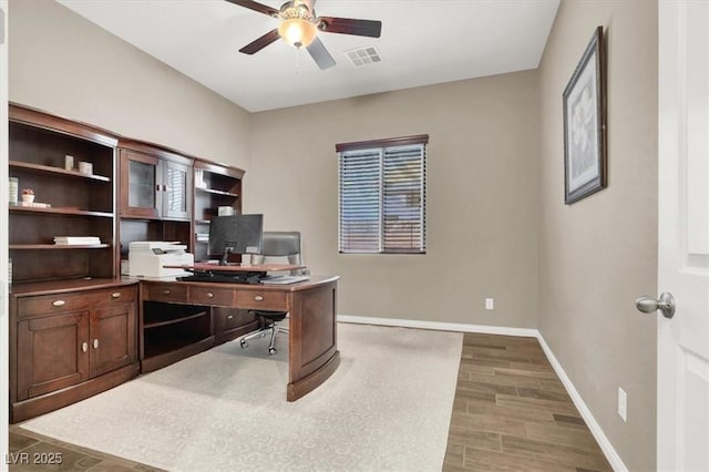 office space with baseboards, wood tiled floor, visible vents, and a ceiling fan