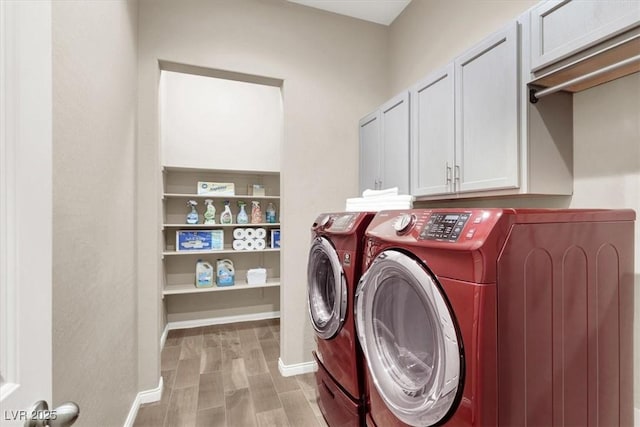 washroom with baseboards, light wood-style floors, cabinet space, and washer and dryer