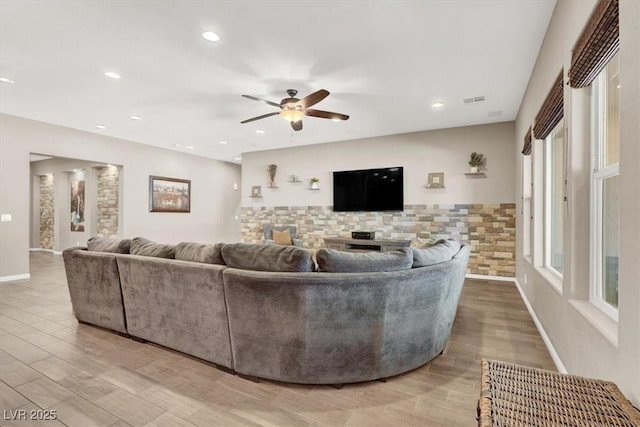 living area featuring visible vents, light wood-type flooring, a ceiling fan, and recessed lighting