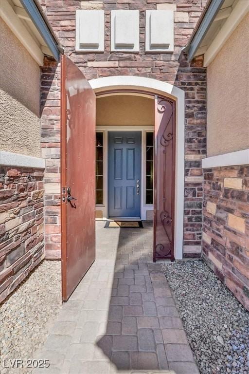 property entrance featuring brick siding and stucco siding