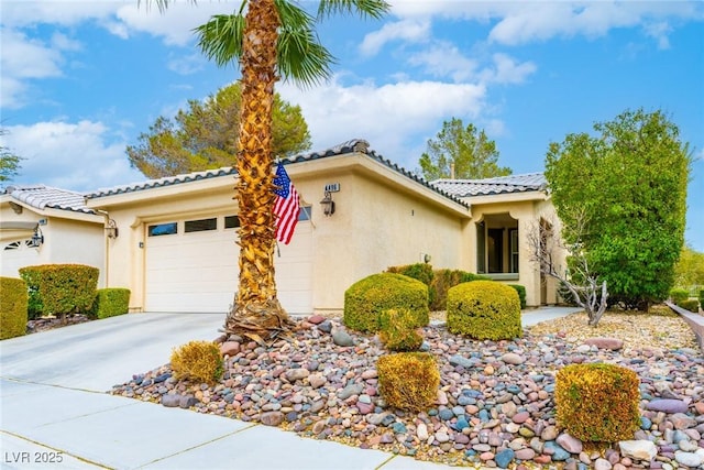 view of front facade with concrete driveway, an attached garage, a tile roof, and stucco siding