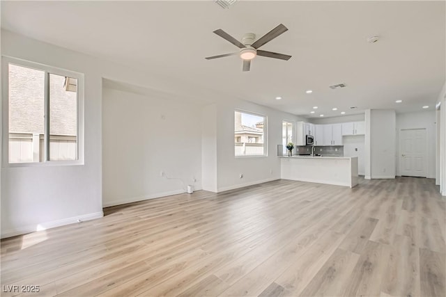 unfurnished living room with light wood-type flooring, ceiling fan, baseboards, and recessed lighting