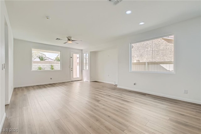 empty room featuring a ceiling fan, light wood-type flooring, and baseboards