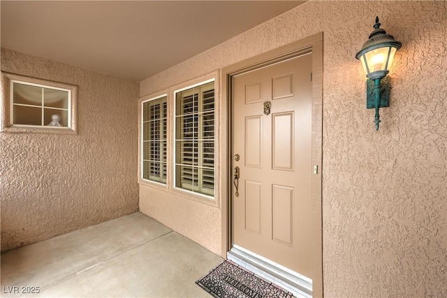 entrance to property featuring stucco siding