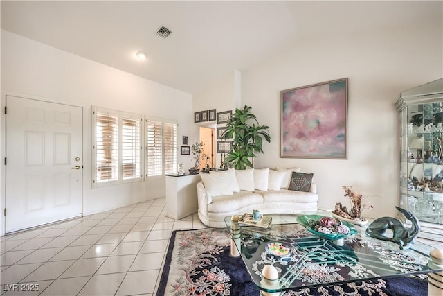 living area with lofted ceiling and light tile patterned flooring