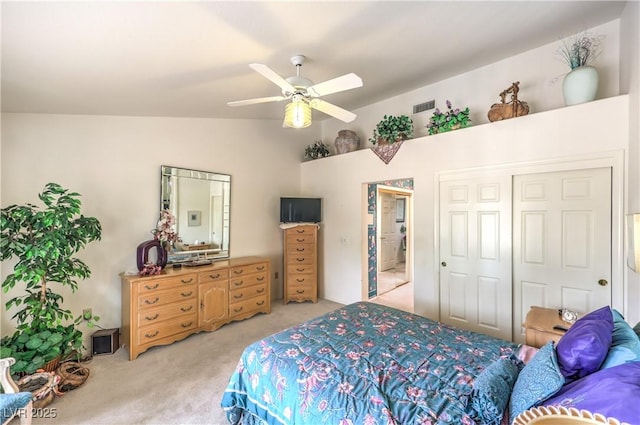 bedroom with visible vents, light colored carpet, lofted ceiling, ceiling fan, and a closet