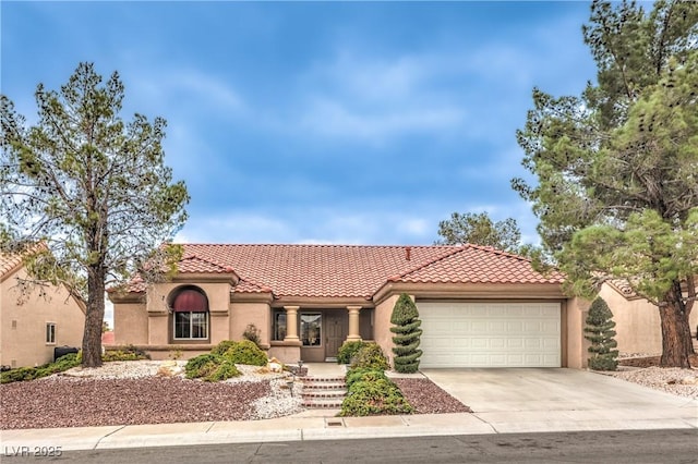 mediterranean / spanish-style home featuring concrete driveway, an attached garage, a tile roof, and stucco siding