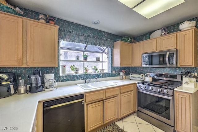 kitchen with light tile patterned floors, appliances with stainless steel finishes, light countertops, and a sink