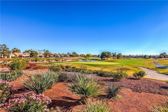 view of property's community with golf course view and a lawn