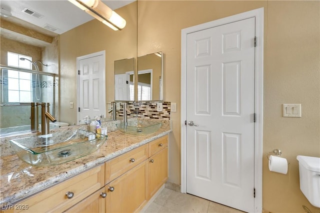 8925 Rio Verde Ave, Las Vegas, NV 89147 - bathroom with visible vents, toilet, tile patterned flooring, a shower stall, and a sink