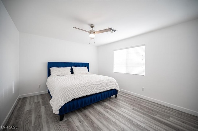 bedroom with wood finished floors, a ceiling fan, and baseboards