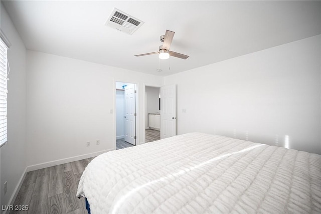 bedroom featuring multiple windows, wood finished floors, visible vents, and baseboards