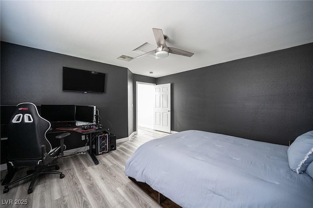 bedroom with a ceiling fan, baseboards, visible vents, and wood finished floors