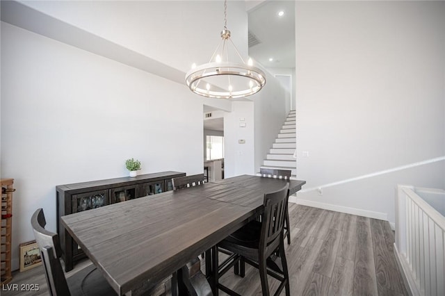 dining room with baseboards, stairway, wood finished floors, a chandelier, and recessed lighting