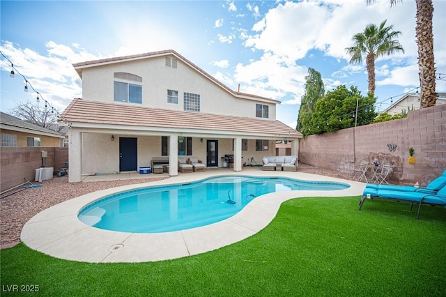 rear view of house with a patio, a fenced backyard, an outdoor living space, a fenced in pool, and stucco siding