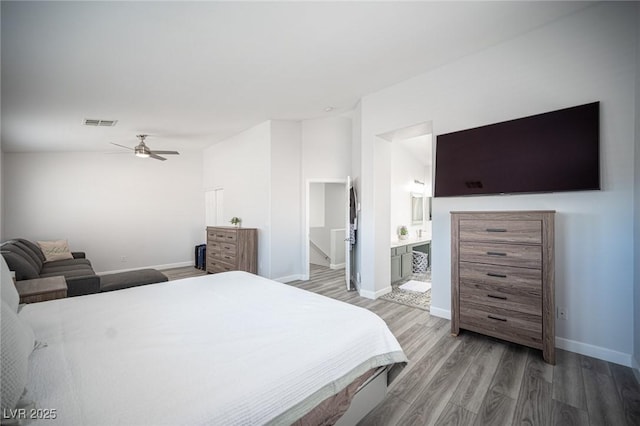 bedroom with ceiling fan, visible vents, baseboards, light wood-type flooring, and ensuite bath