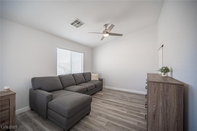 living area with baseboards, visible vents, lofted ceiling, ceiling fan, and wood finished floors