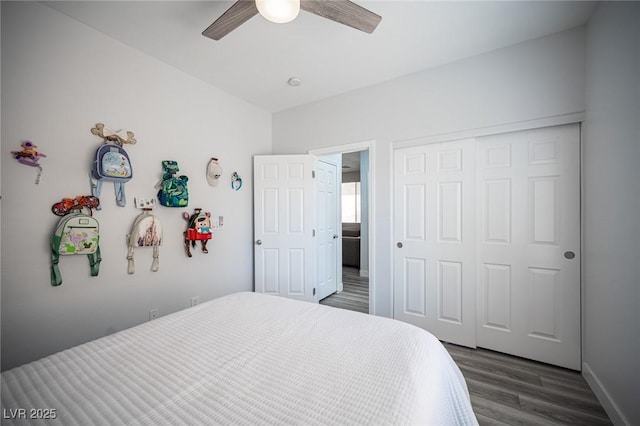 bedroom with dark wood-type flooring, a closet, baseboards, and a ceiling fan