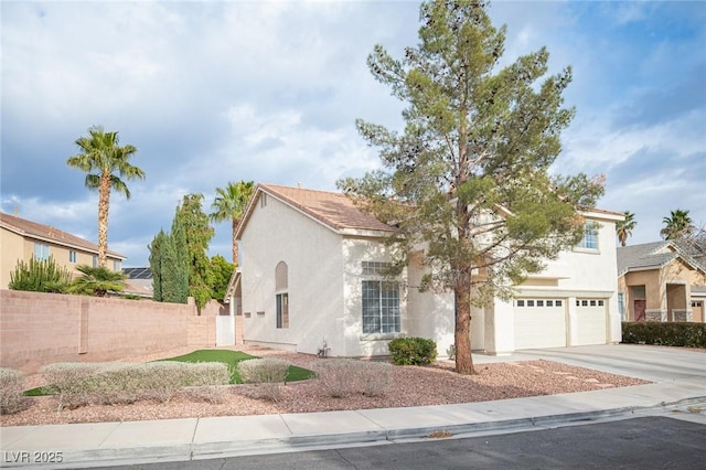 mediterranean / spanish-style home featuring a garage, concrete driveway, fence, and stucco siding