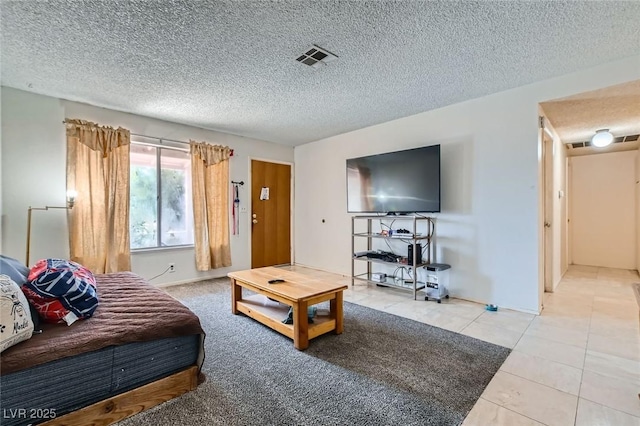 tiled living area with visible vents and a textured ceiling