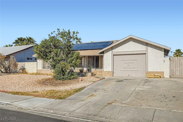 single story home with stucco siding, brick siding, and solar panels