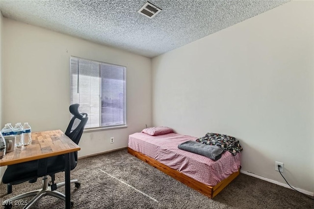 bedroom with a textured ceiling, carpet floors, visible vents, and baseboards