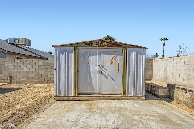 view of shed featuring cooling unit and a fenced backyard