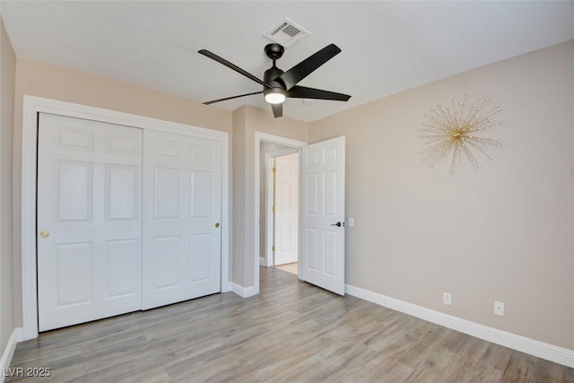 unfurnished bedroom with ceiling fan, light wood-style flooring, visible vents, baseboards, and a closet