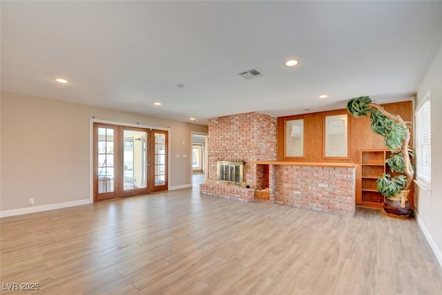 unfurnished living room with light wood-type flooring, visible vents, a fireplace, and recessed lighting