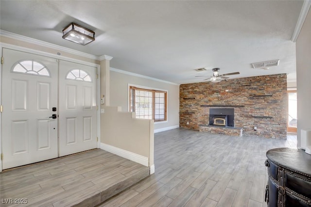 foyer with light wood-style flooring, visible vents, and ornamental molding