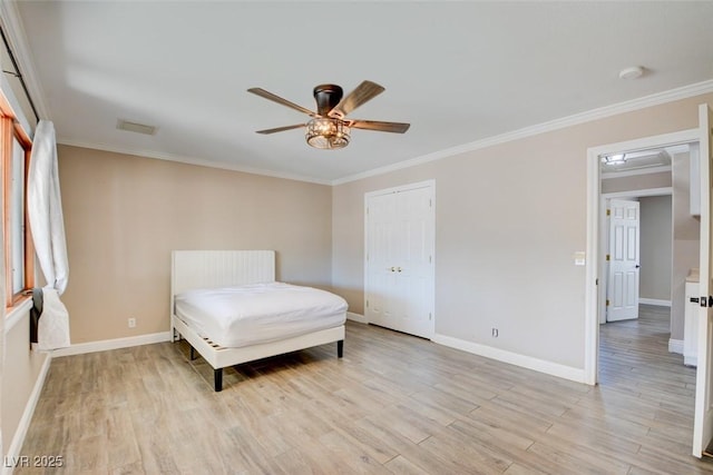 bedroom featuring ornamental molding, light wood finished floors, and visible vents