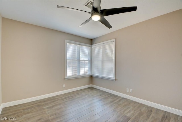 unfurnished room featuring ceiling fan, wood finished floors, visible vents, and baseboards