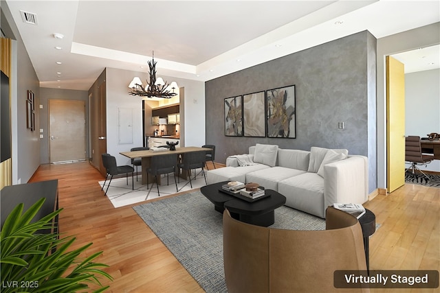 3750 Las Vegas Blvd Unit 2711, Las Vegas, NV 89158 - living area with light wood-style floors, a chandelier, recessed lighting, an accent wall, and a tray ceiling