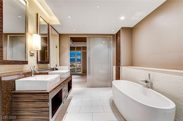 3750 Las Vegas Blvd Unit 2711, Las Vegas, NV 89158 - bathroom with a freestanding tub, double vanity, wainscoting, recessed lighting, and tile patterned flooring