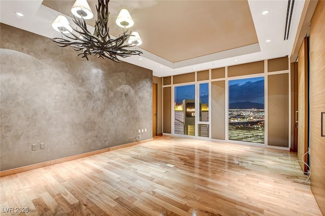 3750 Las Vegas Blvd Unit 2711, Las Vegas, NV 89158 - spare room with a chandelier, wood finished floors, a raised ceiling, and recessed lighting