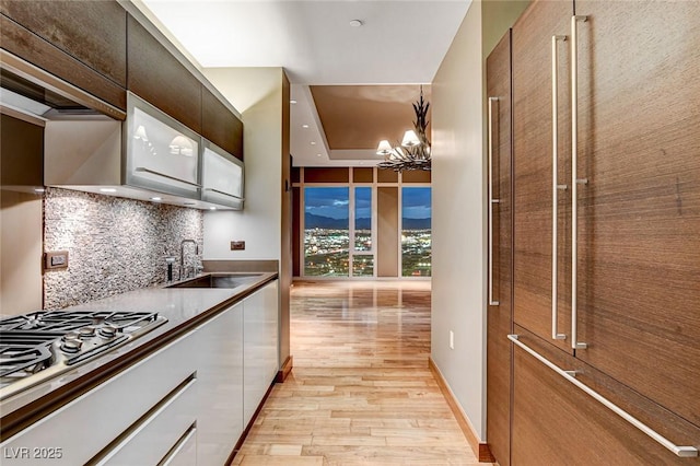 3750 Las Vegas Blvd Unit 2711, Las Vegas, NV 89158 - kitchen featuring stainless steel gas stovetop, light wood-style flooring, a chandelier, backsplash, and modern cabinets