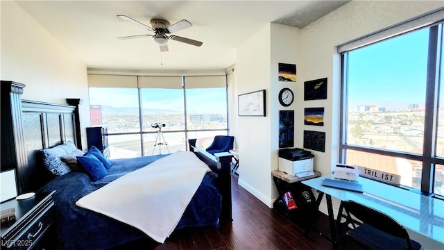 bedroom with expansive windows, multiple windows, baseboards, and wood finished floors