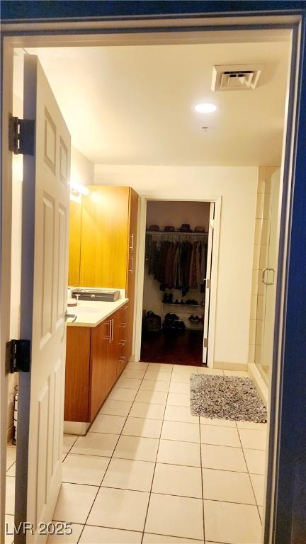 bathroom with vanity, tile patterned flooring, visible vents, and a shower stall