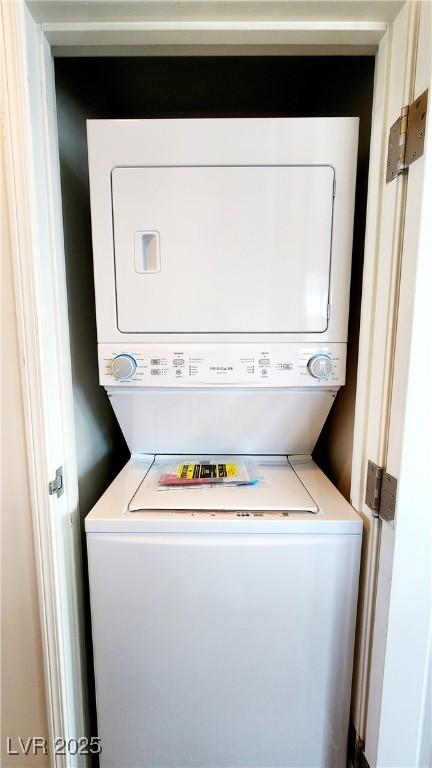 clothes washing area with stacked washer / dryer and laundry area