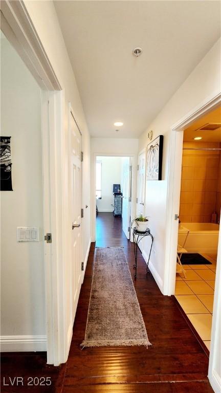 corridor with dark wood finished floors and baseboards